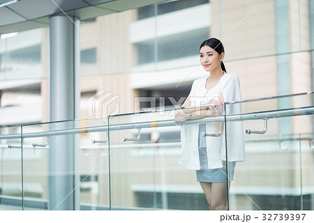 a picture of girl standing near the glass balcony 32739397