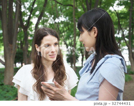 スマートフォンを見る女性(欧米人と日本人) スマートフォンを見る女性(欧米人と日本人) 32744431