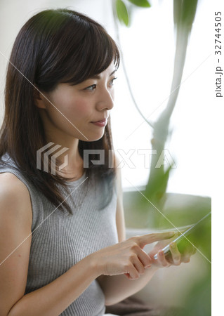 部屋でスマホを使う女性 32744505