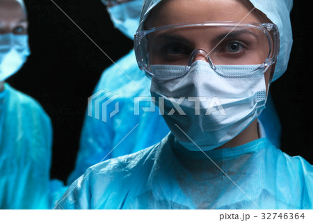 Three surgeons at work operating in surgical Three surgeons at work operating in surgical 32746364
