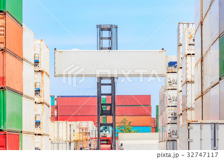 Forklift truck lifting cargo container in shipping Forklift truck lifting cargo container in shipping 32747117