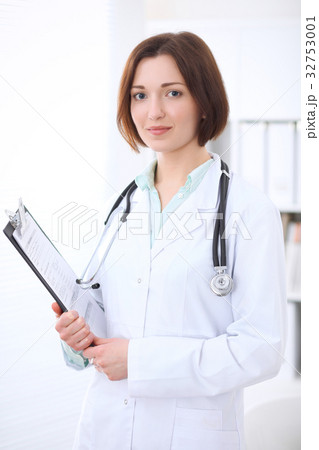 Young brunette female doctor standing with arms Young brunette female doctor standing with arms 32753001