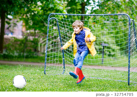 Active cute little kid boy playing soccer and Active cute little kid boy playing soccer and 32754705