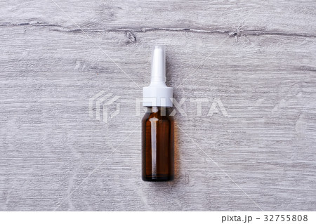 Nasal spray on wooden backdrop. 32755808