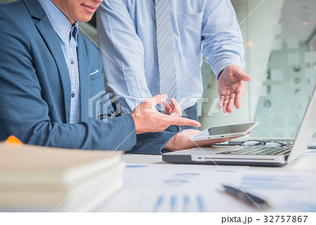 two businessmen discussing project with laptop two businessmen discussing project with laptop 32757867