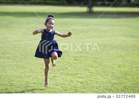 スキップをして遊ぶ女の子の写真素材