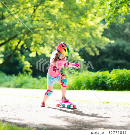 Child riding skateboard in summer park Child riding skateboard in summer park 32775811