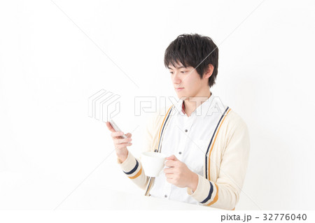 スマホをいじる若い男性の写真素材