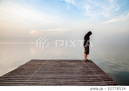 Depressed young man standing on wooden bridge 32778524