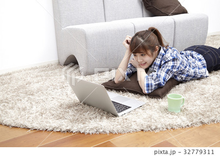 20代女性、パソコン、部屋で寝そべる 32779311
