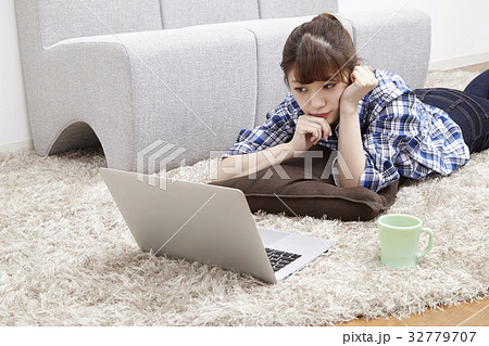 20代女性、パソコン、部屋で寝そべる 32779707
