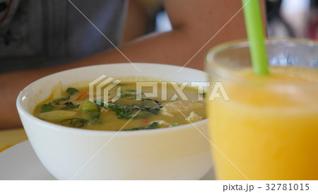 Man eating Thai green curry soup at an outdoor Man eating Thai green curry soup at an outdoor 32781015