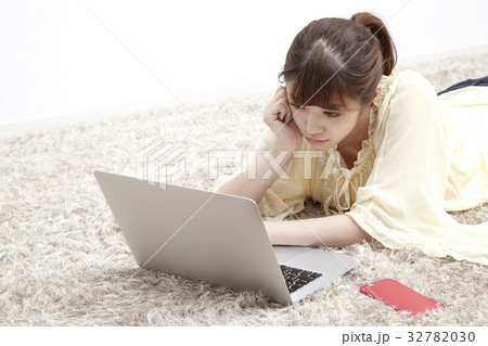 20代女性、パソコン、部屋で寝そべる 32782030