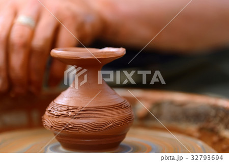 Potter making ceramic pot on the pottery wheel 32793694