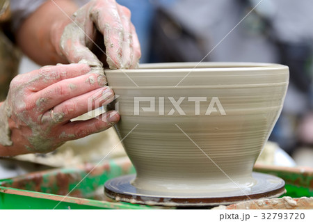 Potter making ceramic pot on the pottery wheel 32793720