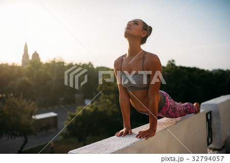 Woman doing yoga exercise, city on background Woman doing yoga exercise, city on background 32794057