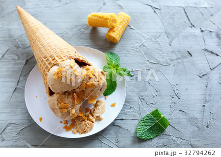 Caramel ice cream in a waffle cone. 32794262