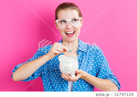 Young woman with a piggy bank 32797220