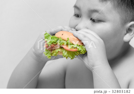 hamburger on obese boy hand Black and white background 32803182