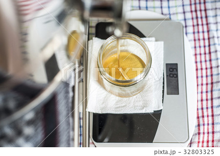 Beekeeper filling up the fresh golden new honey 32803325