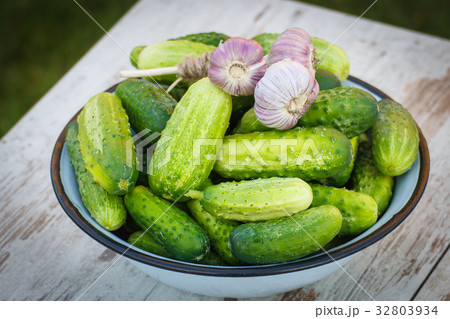 Fresh cucumbers and garlic in bowl 32803934