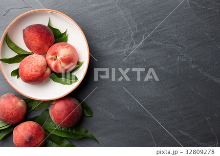 Fresh peaches fruits with leaves on stone background 32809278