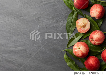 Fresh peaches fruits with leaves on stone background Fresh peaches fruits with leaves on stone background 32809282
