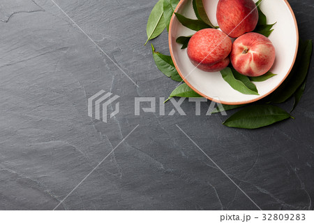 Fresh peaches fruits with leaves on stone background Fresh peaches fruits with leaves on stone background 32809283