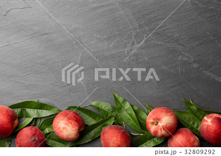 Fresh peaches fruits with leaves on stone background 32809292
