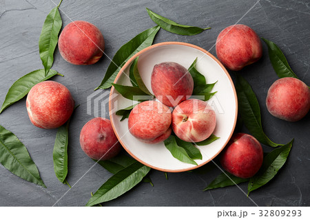 Fresh peaches fruits with leaves on stone background 32809293