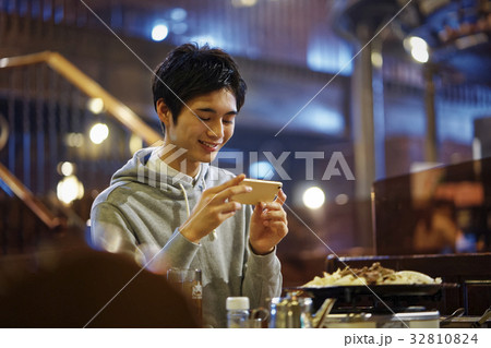 ジンギスカンを味わう男性　スマホ　撮影 32810824