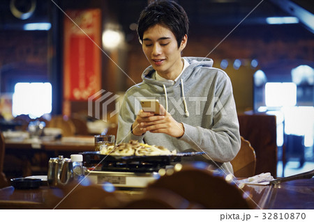 ジンギスカンを味わう男性　スマホ　撮影 32810870
