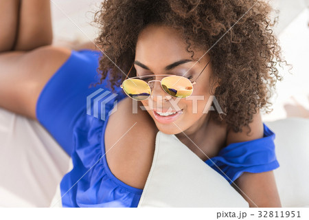 Happy young mulatto girl having rest on beach Happy young mulatto girl having rest on beach 32811951