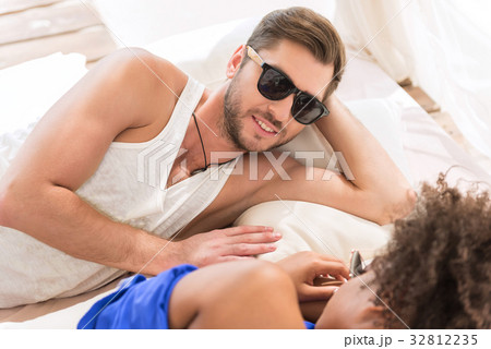 Joyous youthful man enjoying summer rest with his Joyous youthful man enjoying summer rest with his 32812235