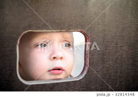 Curious kid spying through the hole in the wall 32814348