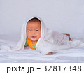 Asian infant lie on the stomach under white towel. 32817348