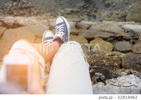 Blue sneaker on girl leg over green sea background 32819962