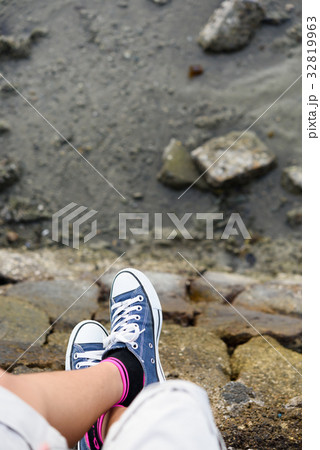 Blue sneaker on girl leg in over green sea  32819963