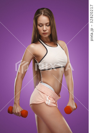 Muscular young woman athlete posing at studio 32820217