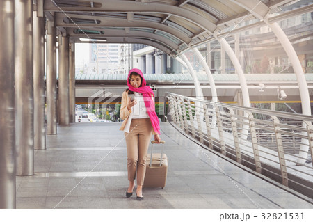 Arab woman walking carrying a suitcase Arab woman walking carrying a suitcase 32821531