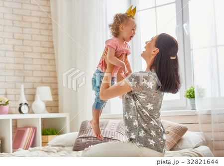 Mother and daughter playing and hugging Mother and daughter playing and hugging 32821644