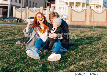 happy mom dad and son hugging in the park happy mom dad and son hugging in the park 32822569