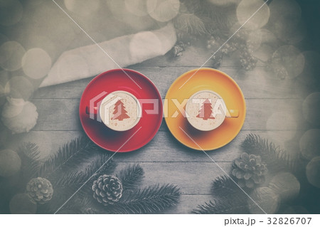 Two cappuccino on and hat with branch  32826707