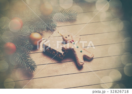 Gingerbread man and gift on wooden table. 32826718