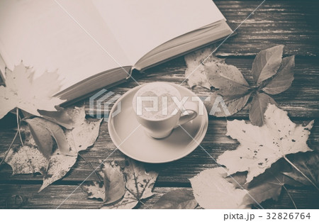 Autumn leaves, book and coffee cup on table. Autumn leaves, book and coffee cup on table. 32826764