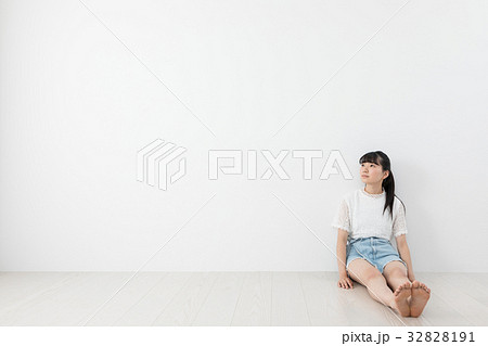 壁に寄り掛かる若い女性　 32828191