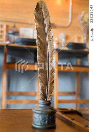 Metal bird feather on leather background 32835347