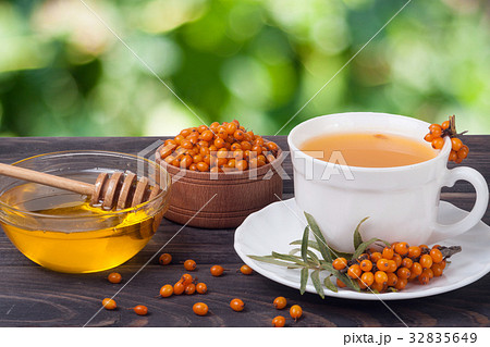 Tea of sea-buckthorn berries with honey on wooden 32835649
