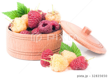 red and yellow raspberries in wooden bowl isolated red and yellow raspberries in wooden bowl isolated 32835650