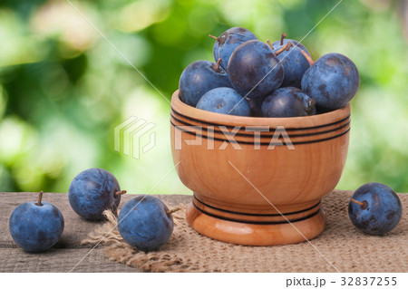 blackthorn berries in a wooden bowl on table with blackthorn berries in a wooden bowl on table with 32837255